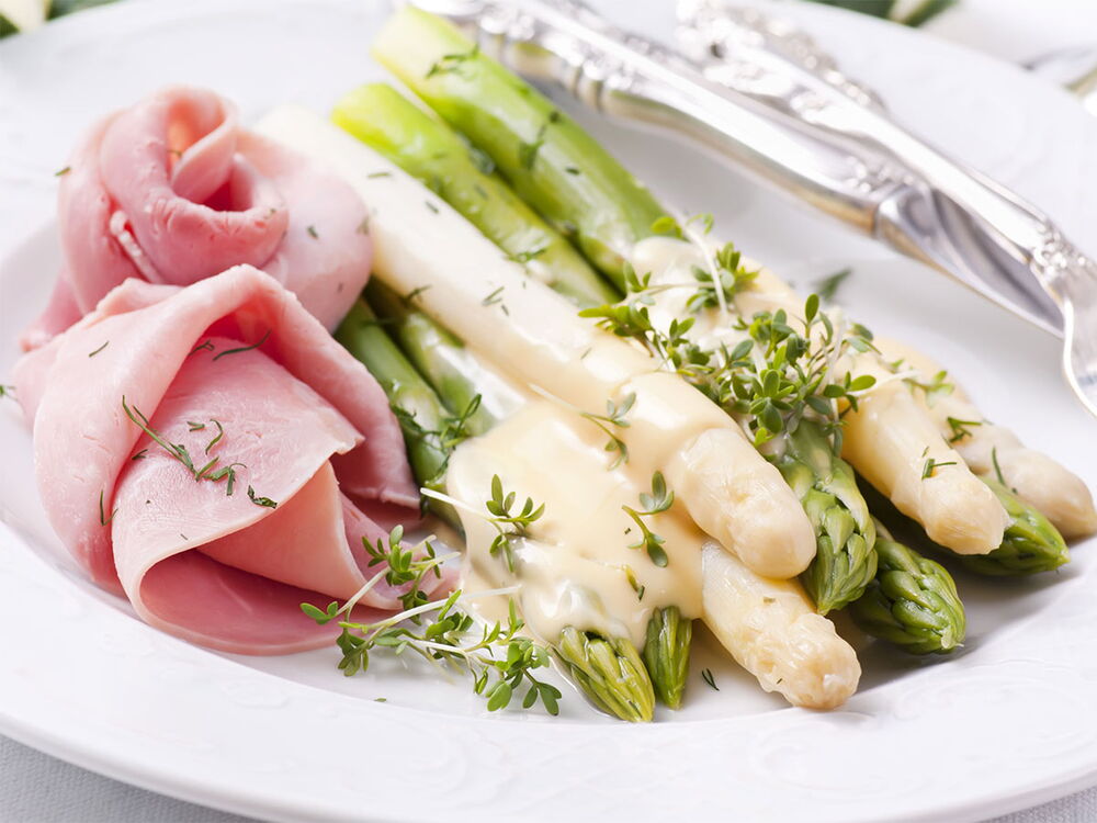 Spargelgericht auf einem Teller mit Soße angerichtet